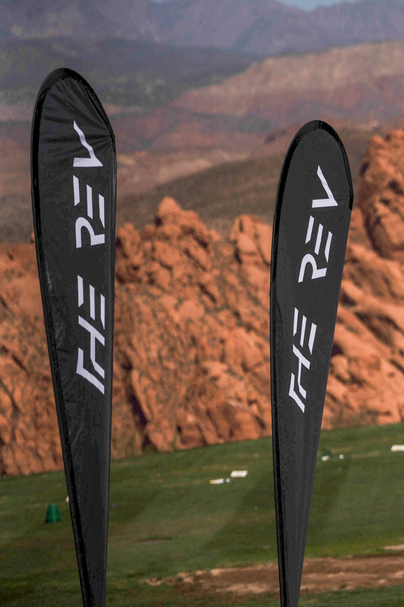 Two black HE P24 skis standing upright in desert landscape with red rock formations in background