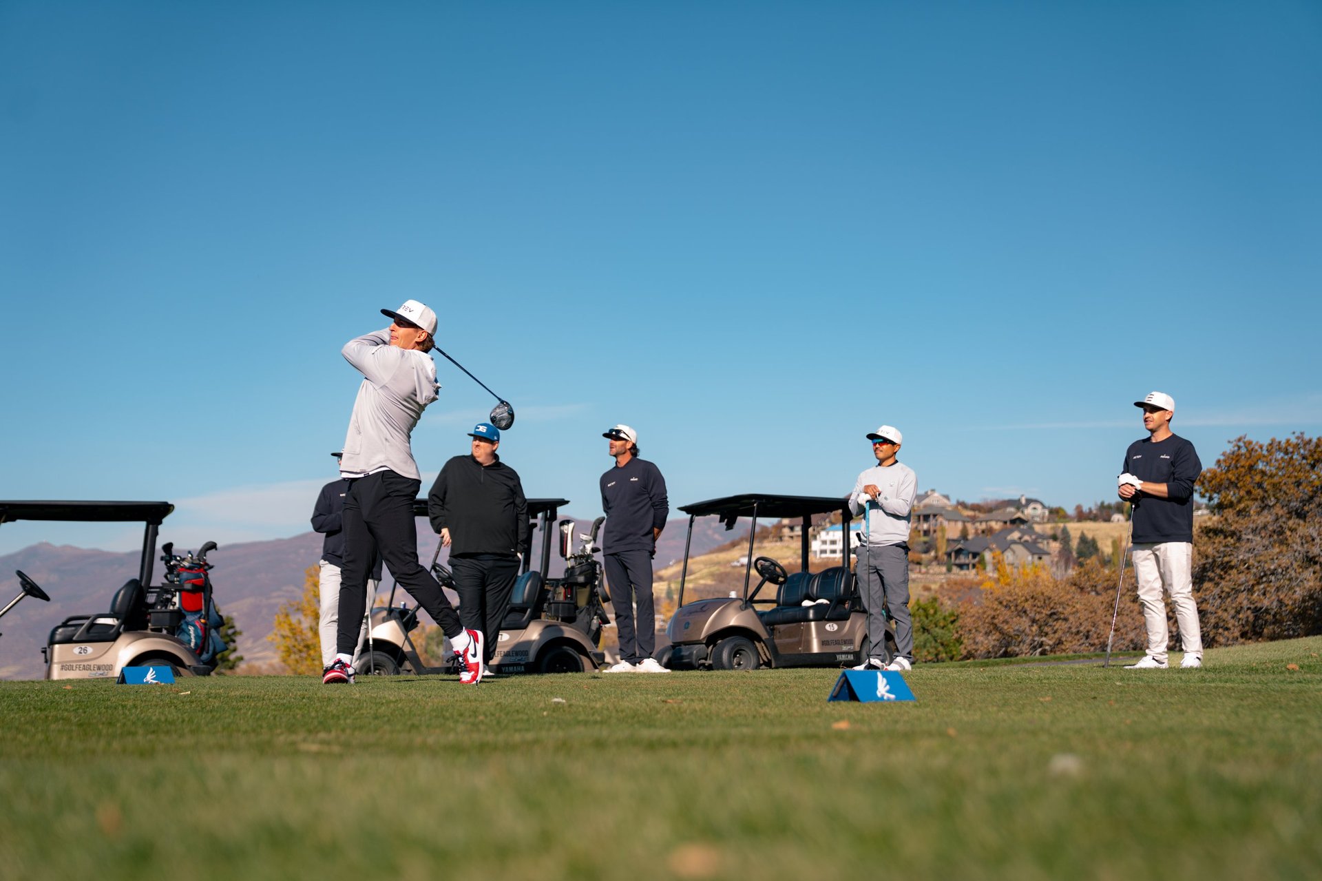 Golf flagsticks on a Southern Utah course with red rock formations in the background — REV Tour STG year-round golf league.